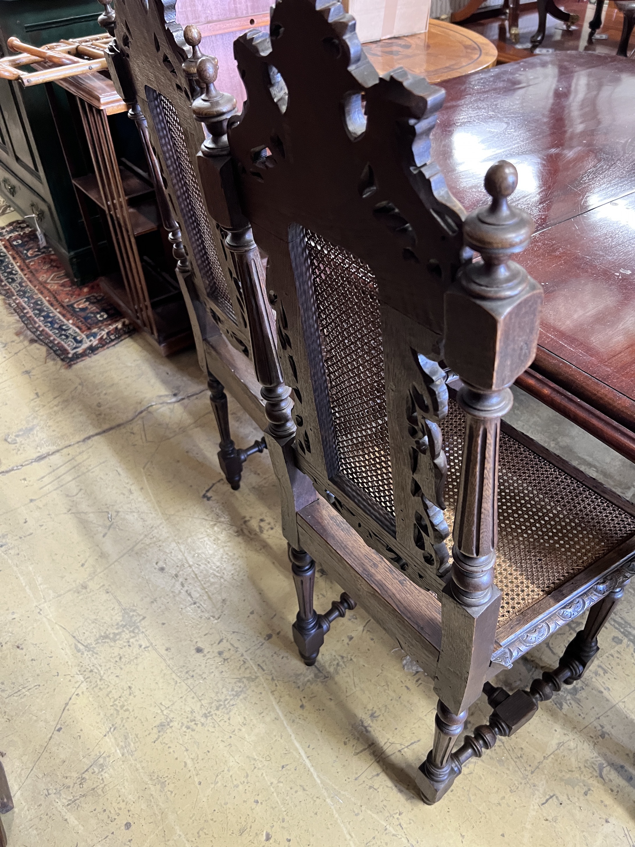 A set of four late 19th century Flemish style carved oak dining chairs with caned seats